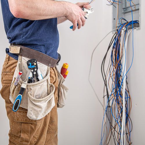 Un électricien vérifie les connexions d’un tableau électrique